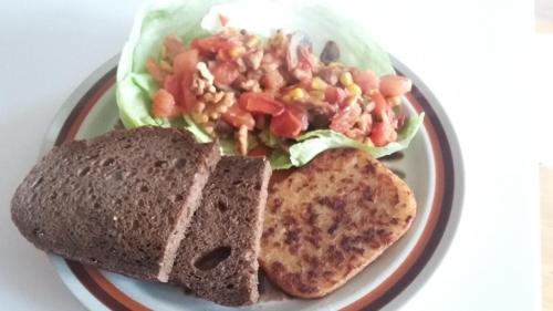 a plate of food with bread and a salad and a sandwich at Vancouver Traveller B&B in Vancouver