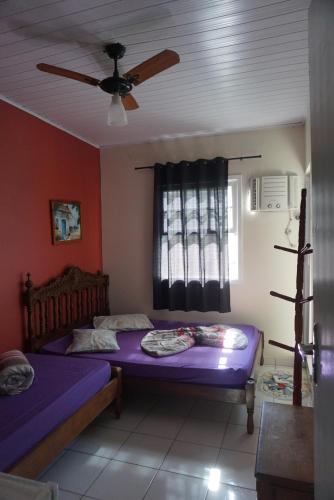 a bedroom with two beds and a ceiling fan at Pousada Orquidário in Santos