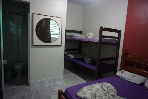 a room with two bunk beds and a mirror at Pousada Orquidário in Santos
