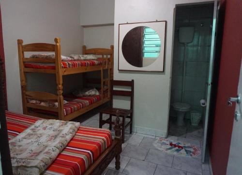 a bedroom with two bunk beds and a shower at Pousada Orquidário in Santos