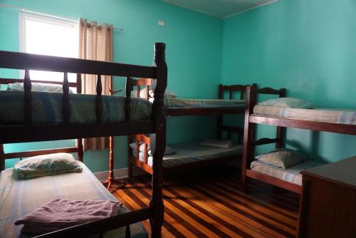 a room with three bunk beds and a window at Pousada Orquidário in Santos