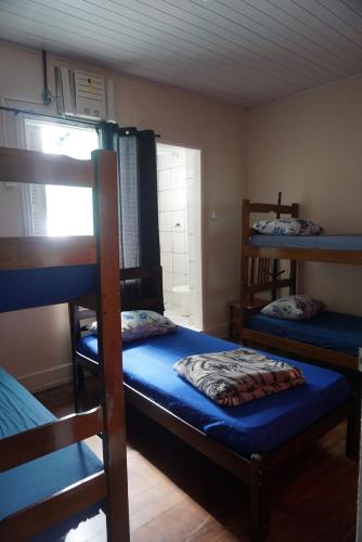 a room with three bunk beds and a window at Pousada Orquidário in Santos