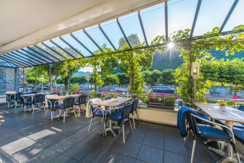 a dining area with tables, chairs and umbrellas at Hotel Karl Müller in Cochem