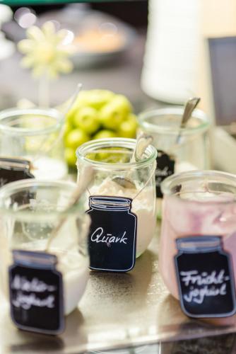 a table topped with glass jars filled with food at Romantik Hotel Ahrenberg in Bad Sooden-Allendorf