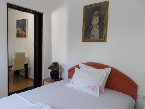 a bedroom with a bed with a portrait of a child at Apartmani Ivona in Budva