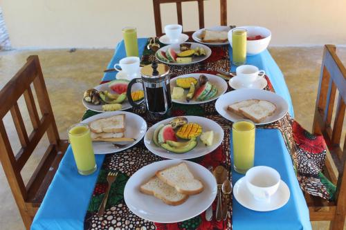 a blue table with plates of food on it at Mafia Neptune Villa Lodge in Utende