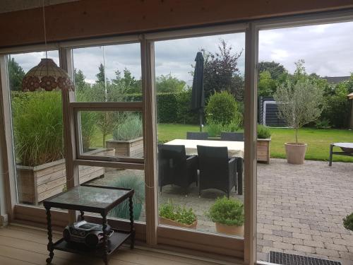 a screened in porch with a view of a garden at 1 room with private Bath in Allingåbro