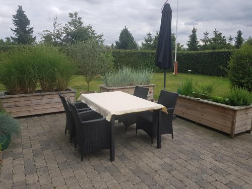 a table and chairs and an umbrella on a patio at 1 room with private Bath in Allingåbro