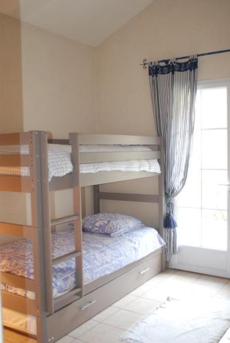 1 dormitorio con 2 literas y ventana en Gîte de la Remaudière, en Le Poiré-sur-Vie