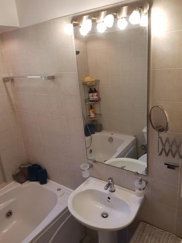a bathroom with a sink and a tub and a mirror at 'Seaside Paradise' Elegant Apartment in Nea Makri in Nea Makri