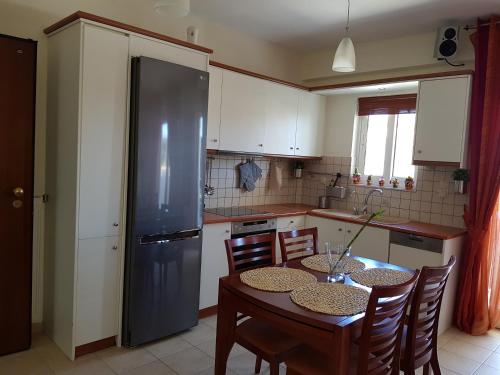 a kitchen with a table with chairs and a refrigerator at 'Seaside Paradise' Elegant Apartment in Nea Makri in Nea Makri