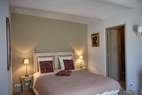 a bedroom with a large bed with two lamps at Le Pré de l'Aube in Montjoyer