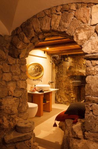 a stone bathroom with a toilet and a sink at Living History (adults only) in Hallstatt