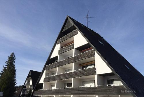 um edifício com um telhado triangular com uma cruz em 71 square meters Condo in Schwarzwald with beautiful mountain view, free wifi em Schönwald
