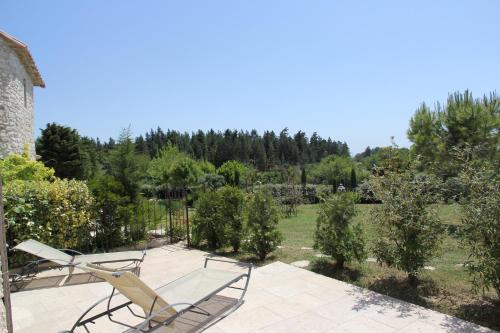 a patio with chairs and a view of a garden at Le Pré de l'Aube in Montjoyer