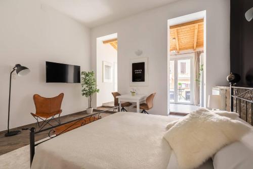 a white bedroom with a bed and a table and chair at Royal Piazza di Spagna in Rome