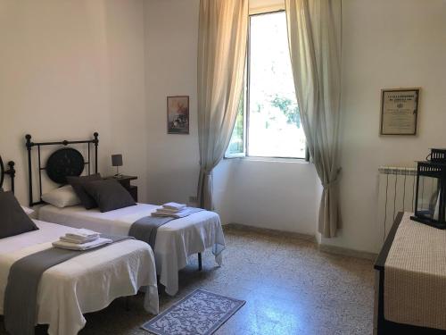 sypialnia z dwoma łóżkami i oknem w obiekcie Central House Terracina w mieście Terracina