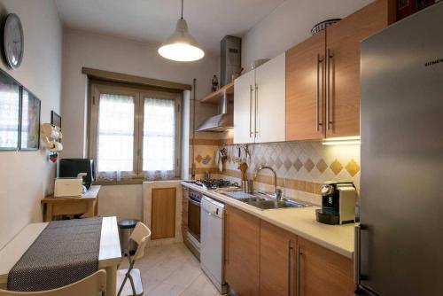 a kitchen with wooden cabinets and a sink and a table at Eucalyptus Resort - Roma San Paolo - in Rome