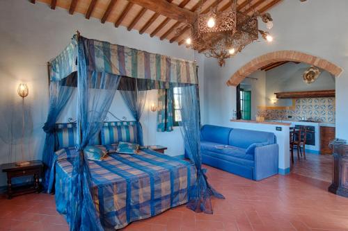 a bedroom with a blue bed and a couch at Podere La Ciabatta in Casole dʼElsa