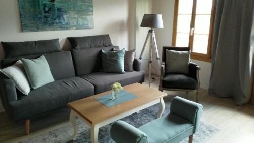 a living room with a couch and a table and chairs at App. Seeblick Top of Interlaken in Beatenberg