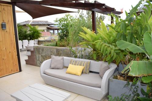 a couch sitting on a patio with plants at Belle Crique D3 Tamarin Ile Maurice in Tamarin