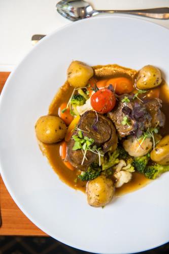a white plate of food with potatoes and vegetables at Hotel Karl Müller in Cochem