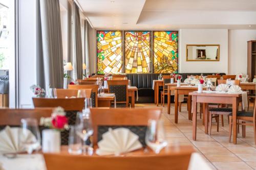 a restaurant with tables and chairs and a stained glass window at Hotel Karl Müller in Cochem