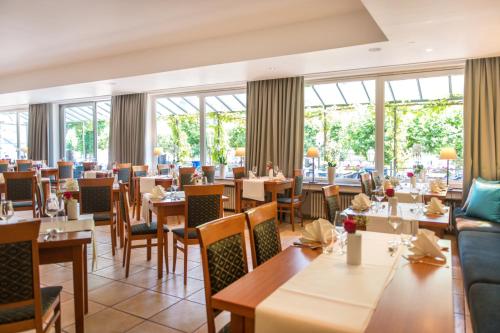 a restaurant with tables and chairs and windows at Hotel Karl Müller in Cochem