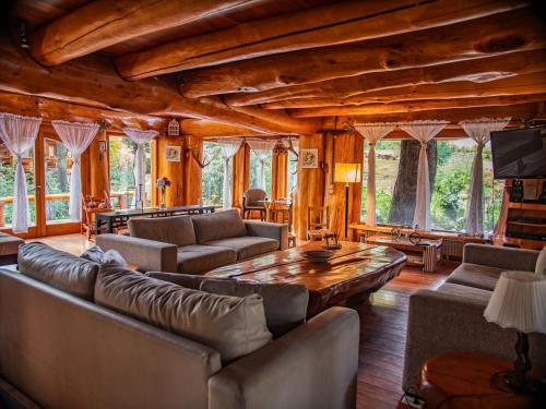 sala de estar con sofás y mesa en Rotui Cabaña Exclusiva La Juanita en San Martín de los Andes