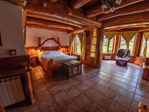 1 dormitorio con 1 cama en una habitación con techos de madera en Rotui Cabaña Exclusiva La Juanita en San Martín de los Andes