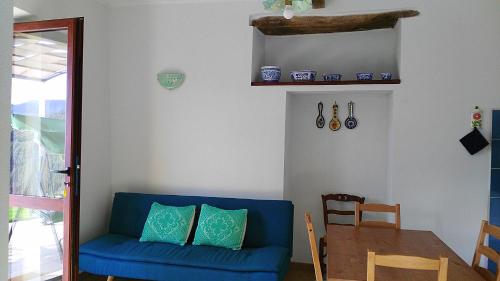 ein Wohnzimmer mit einem blauen Sofa und einem Tisch in der Unterkunft La Peonia casa vacanze in montagna prato verde panorama stupendo Sardegna in Seùlo