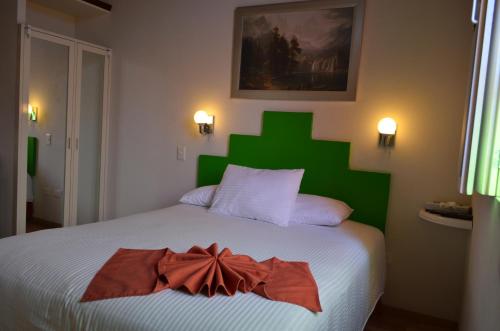 a bedroom with a bed with a bow on it at HOTEL DEL CAPITAN DE PUEBLA, DEPARTAMENTOS in Puebla