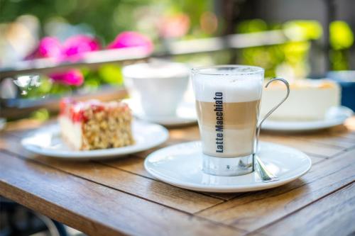 a cup of coffee and a piece of cake on a table at Hotel Karl Müller in Cochem