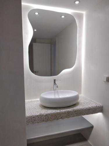 a bathroom with a sink and a mirror at Marina's Suites in Naxos Chora