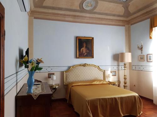 a bedroom with a bed and a vase of flowers on a table at Villa il Lauro in Pisa