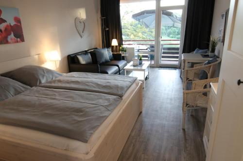 a bedroom with a bed and a living room at Seaside Appartement 341 Vier Jahreszeiten in Hahnenklee-Bockswiese