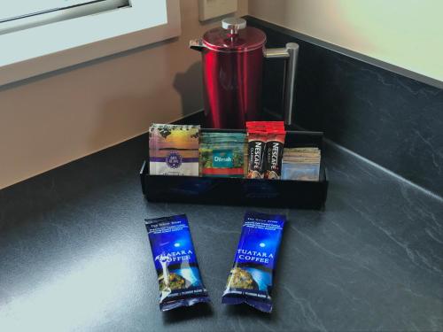 two packets of toothpaste sitting on a counter next to a blender at Phoenix Motels in Temuka