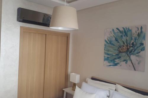 a bedroom with a bed and a painting on the wall at A 200m de la Plage, du Haut Standing au coeur du Parc in Mohammedia