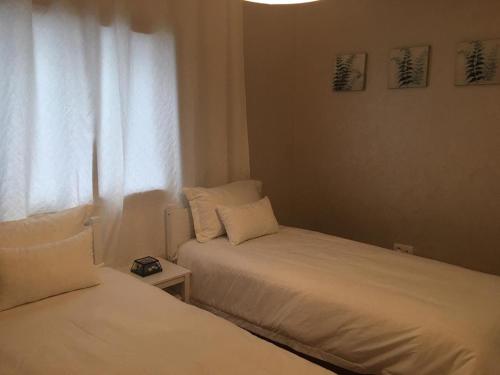two beds in a small room with a window at A 200m de la Plage, du Haut Standing au coeur du Parc in Mohammedia