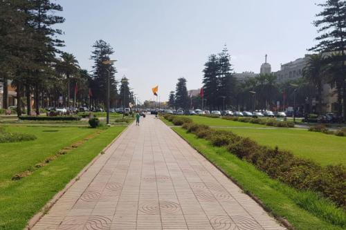 a person walking down a sidewalk in a park at A 200m de la Plage, du Haut Standing au coeur du Parc in Mohammedia