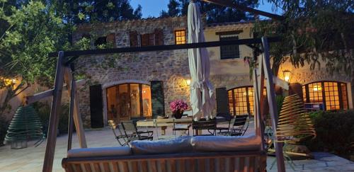een patio met een bank en een tafel en stoelen bij La Teze in Le Castellet