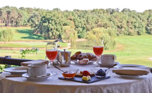a table with glasses of wine and food on it at Golf Hotel Castelconturbia in Agrate Conturbia