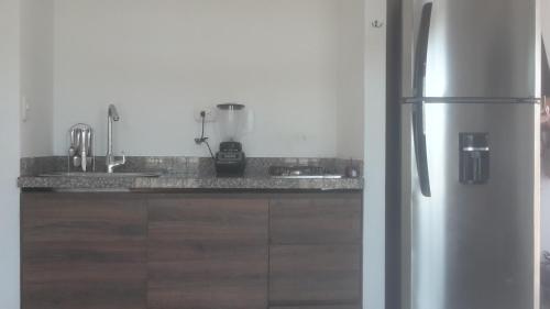 uma cozinha com um frigorífico de aço inoxidável e armários de madeira em VILLA MORELI em Papare