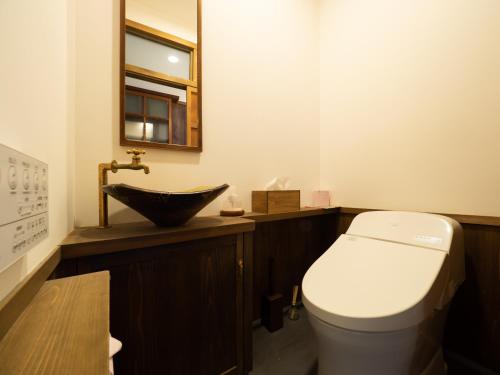 a bathroom with a toilet and a sink at Inase Otsu Machiya Bed and Breakfast in Otsu