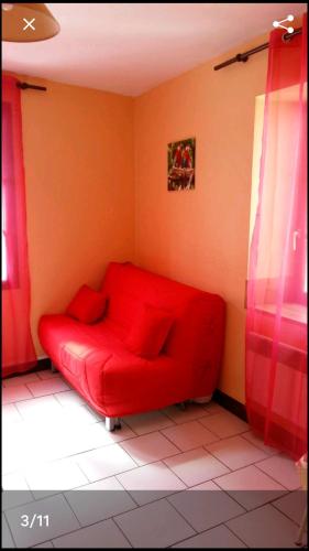 un divano rosso in un angolo di una stanza di Appart centre ville Auxerre ad Auxerre
