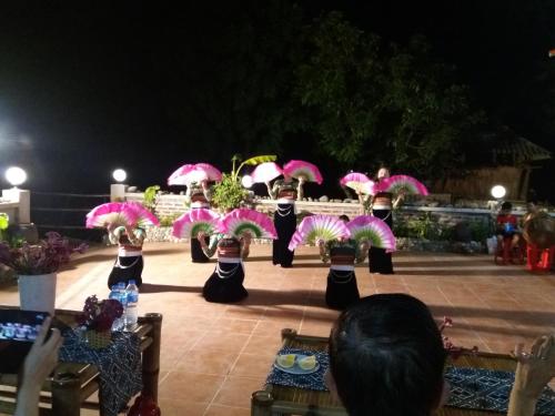 a group of people holding pink umbrellas at Mai Chau Xanh Bungalow in Mai Chau