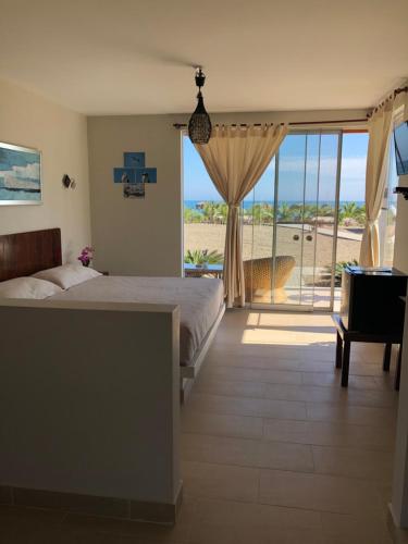 a bedroom with a bed and a view of the ocean at El Samay Hotel Boutique in Canoas De Punta Sal