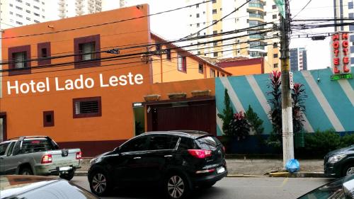 um carro preto estacionado em frente a um hotel labelo leslie em Hotel Lado Leste em São Paulo