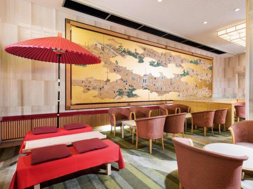 京都市にある京都 新阪急ホテルのテーブルと椅子が備わる大きな壁画のあるレストラン