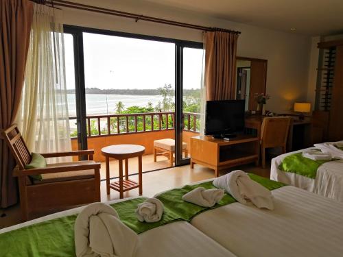 a hotel room with two beds and a balcony at Islanda Resort Hotel in Ko Mak